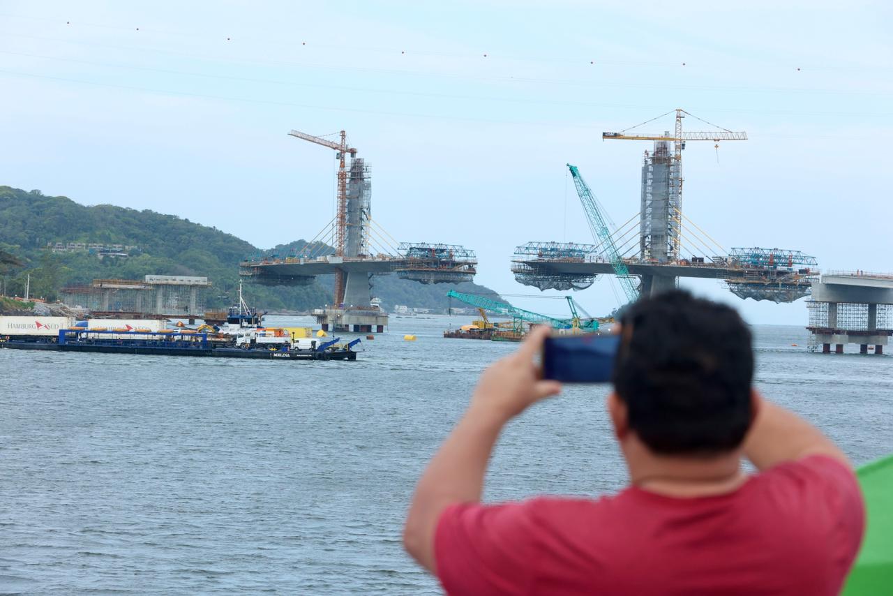 Pessoa tirando foto da obra da ponte de guaratuba