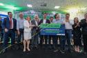 pessoas no palco segurando um cartaz e comemorando