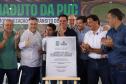 pessoas em frente a placa de inauguração do viaduto puc