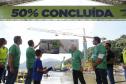 pessoas olhando a Placa de "50% concluída"