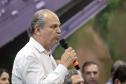 Homem falando de cima de um palco