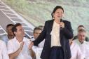 Mulher discursando em cima do palco
