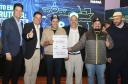 pessoas posando com papel de liberação de recursos