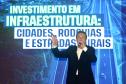 Homem falando no microfone em cima do palco