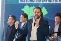 Homem falando no microfone em cima do palco