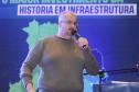 Homem falando no microfone em cima do palco