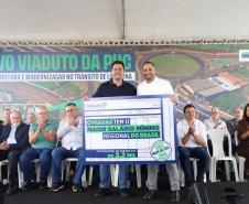 pessoas em frente a placa de inauguração do viaduto puc