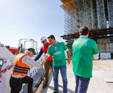homens descendo do barco para ver a obra