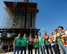 homens posando para a foto em frente a obra