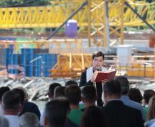 Padre Reginaldo Manzotti lendo a bíblia em cima do palco