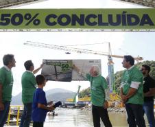 pessoas olhando a  Placa de "50% concluída"