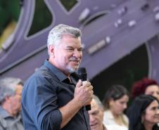 Homem falando de cima de um palco