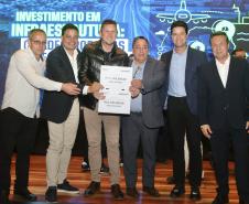 pessoas posando com papel de liberação de recursos