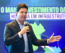 Homem falando no microfone em cima do palco