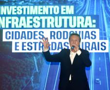 Homem falando no microfone em cima do palco