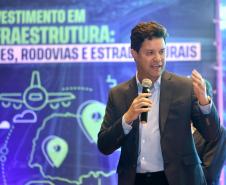 Homem falando no microfone em cima do palco