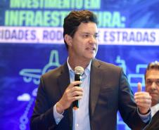 Homem falando no microfone em cima do palco