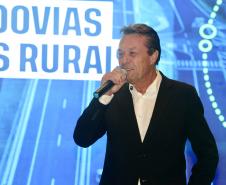 Homem falando no microfone em cima do palco