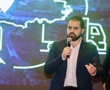 Homem falando no microfone em cima do palco