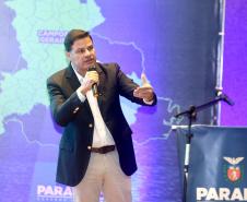 Homem falando no microfone em cima do palco