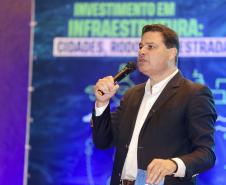 Homem falando no microfone em cima do palco