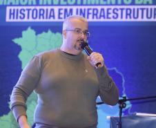 Homem falando no microfone em cima do palco