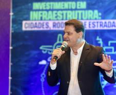 Homem falando no microfone em cima do palco