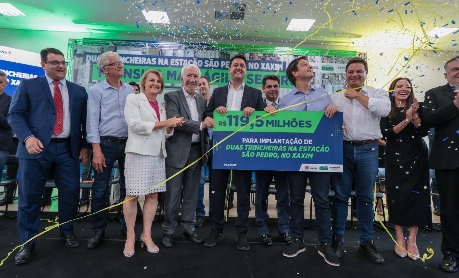 pessoas no palco segurando um cartaz e comemorando