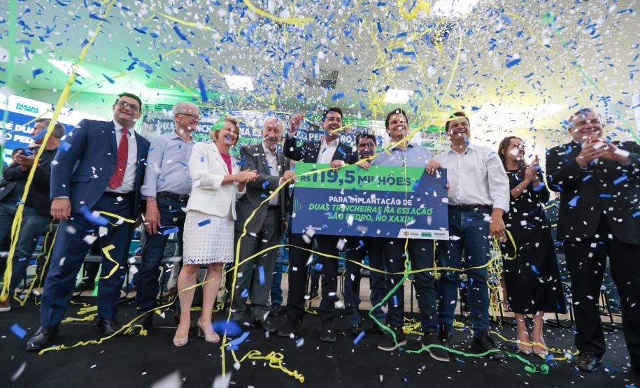pessoas no palco segurando um cartaz e comemorando
