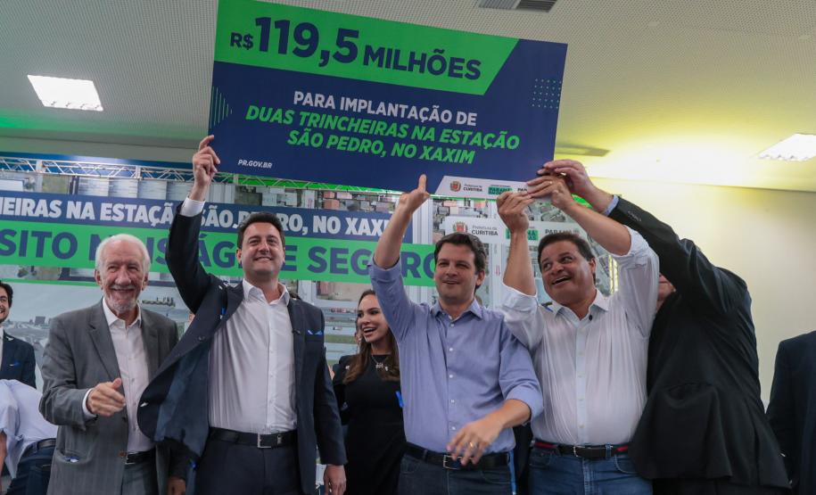 pessoas no palco segurando um cartaz e comemorando