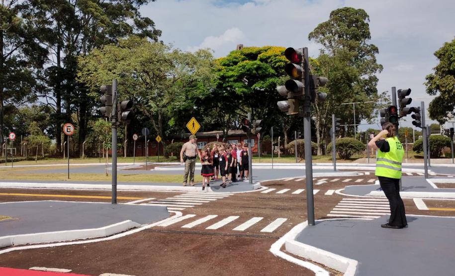 Crianças na Escola de Trânsito atravessando a rua com um instrutores da escola