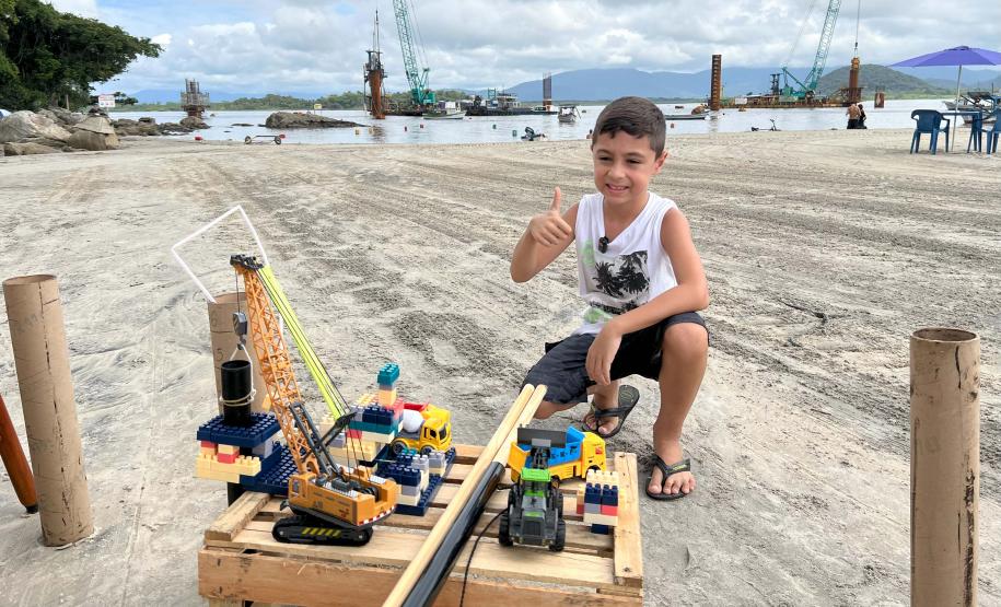 O menino, Felipe Benvinda Guszaki, de 7 anos, usando peças de montar, carrinhos e bonecos de brinquedo para recriar a obra