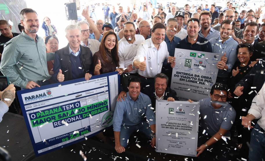 pessoas em frente a placa de inauguração do viaduto puc