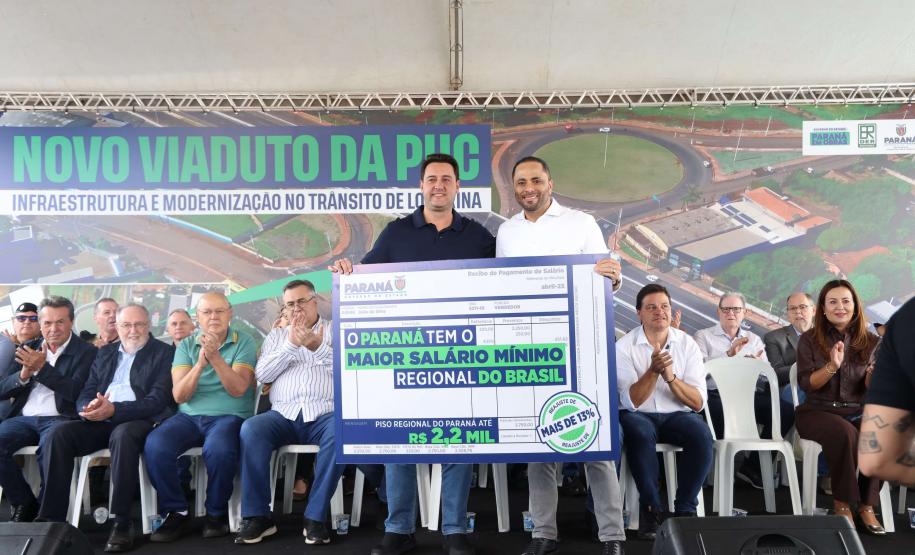 pessoas em frente a placa de inauguração do viaduto puc