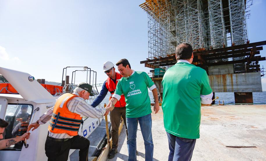 homens descendo do barco para ver a obra