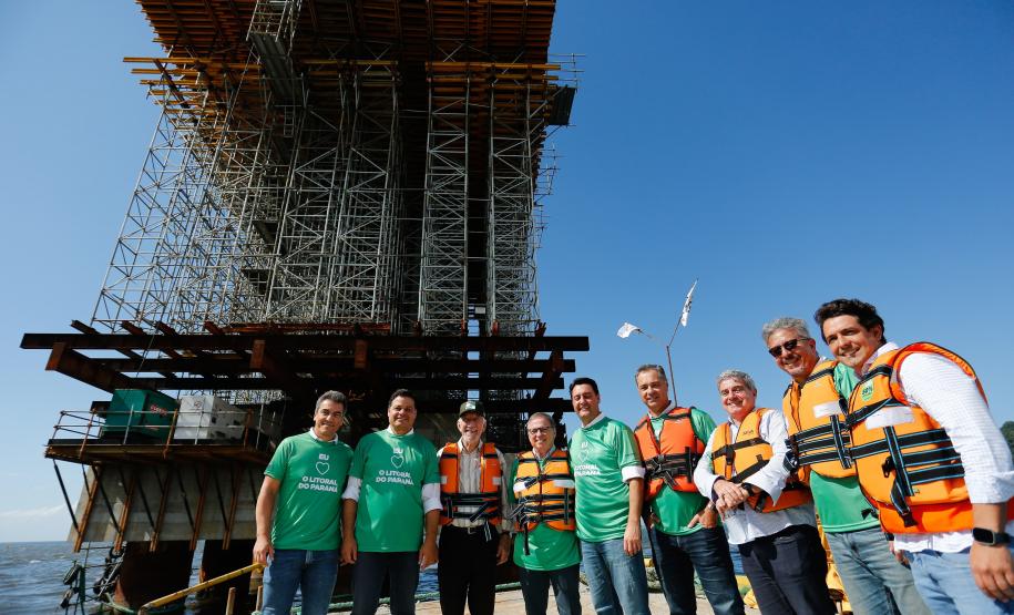 homens posando para a foto em frente a obra