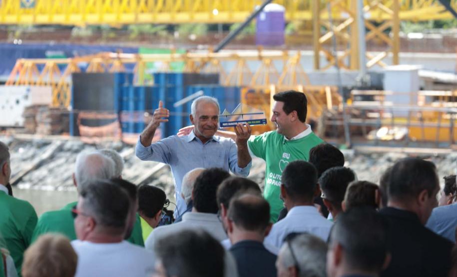homem segurando uma "placa" da ponte de guaratuba