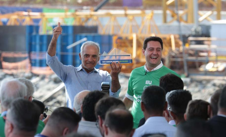 homem segurando a "placa" da obra