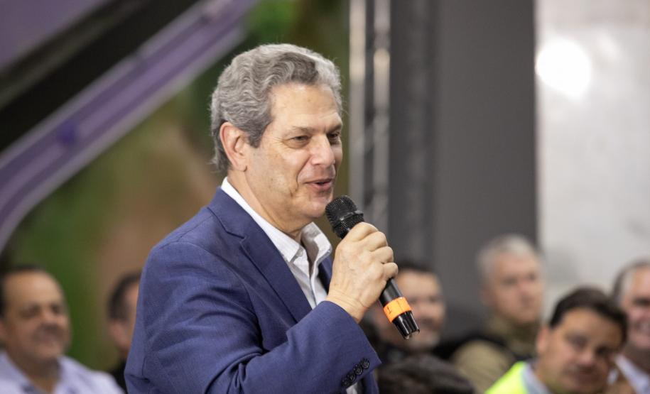 Homem falando de cima de um palco