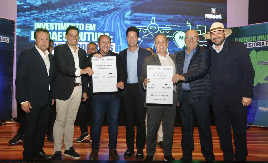 pessoas posando com papel de liberação de recursos