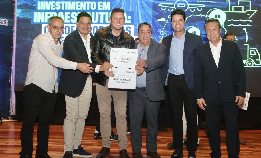 pessoas posando com papel de liberação de recursos