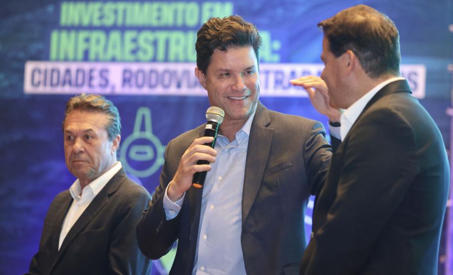 Homem falando no microfone em cima do palco