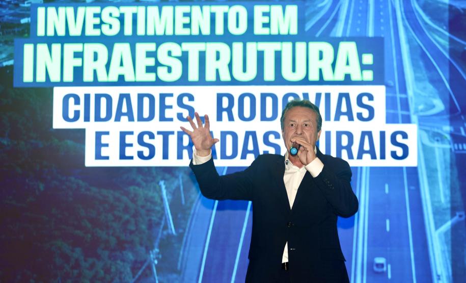 Homem falando no microfone em cima do palco
