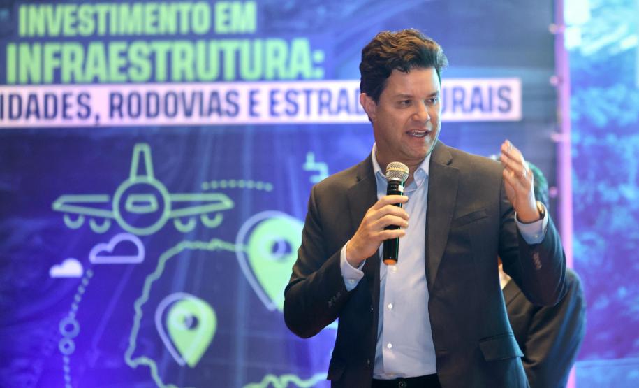 Homem falando no microfone em cima do palco