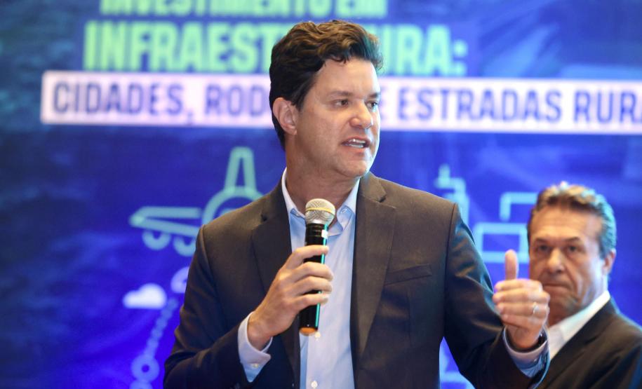 Homem falando no microfone em cima do palco