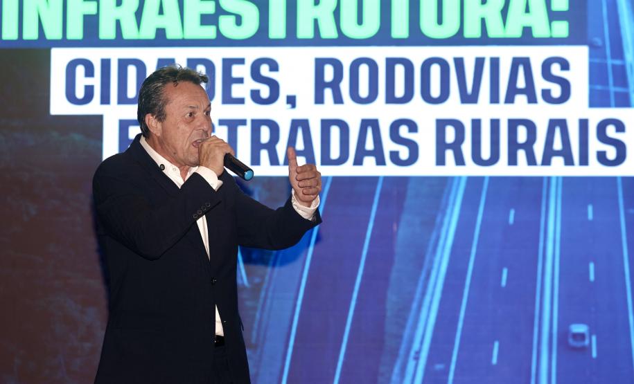 Homem falando no microfone em cima do palco