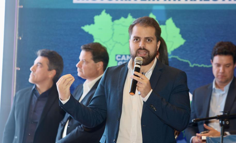 Homem falando no microfone em cima do palco