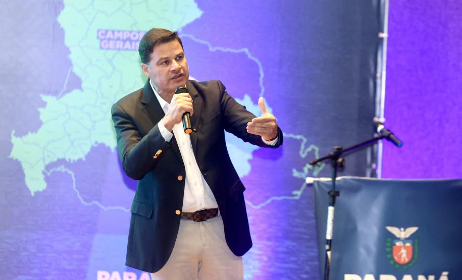 Homem falando no microfone em cima do palco