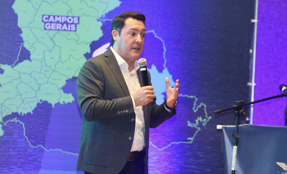 Homem falando no microfone em cima do palco