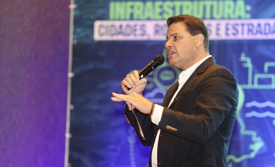 Homem falando no microfone em cima do palco